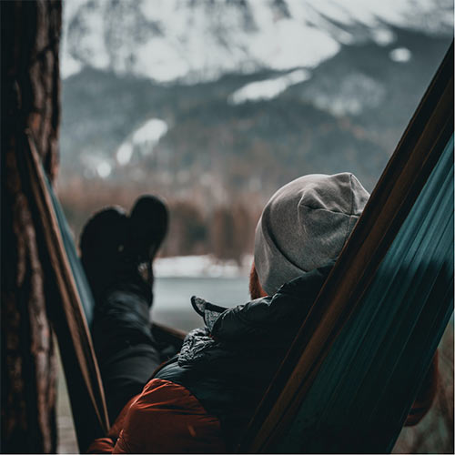 Illustration de perte de poids au masculin : homme dans un hamac face à la montagne